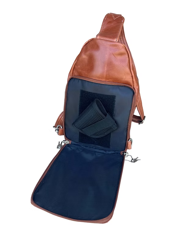 Brown leather sling bag with open front pocket on a white background