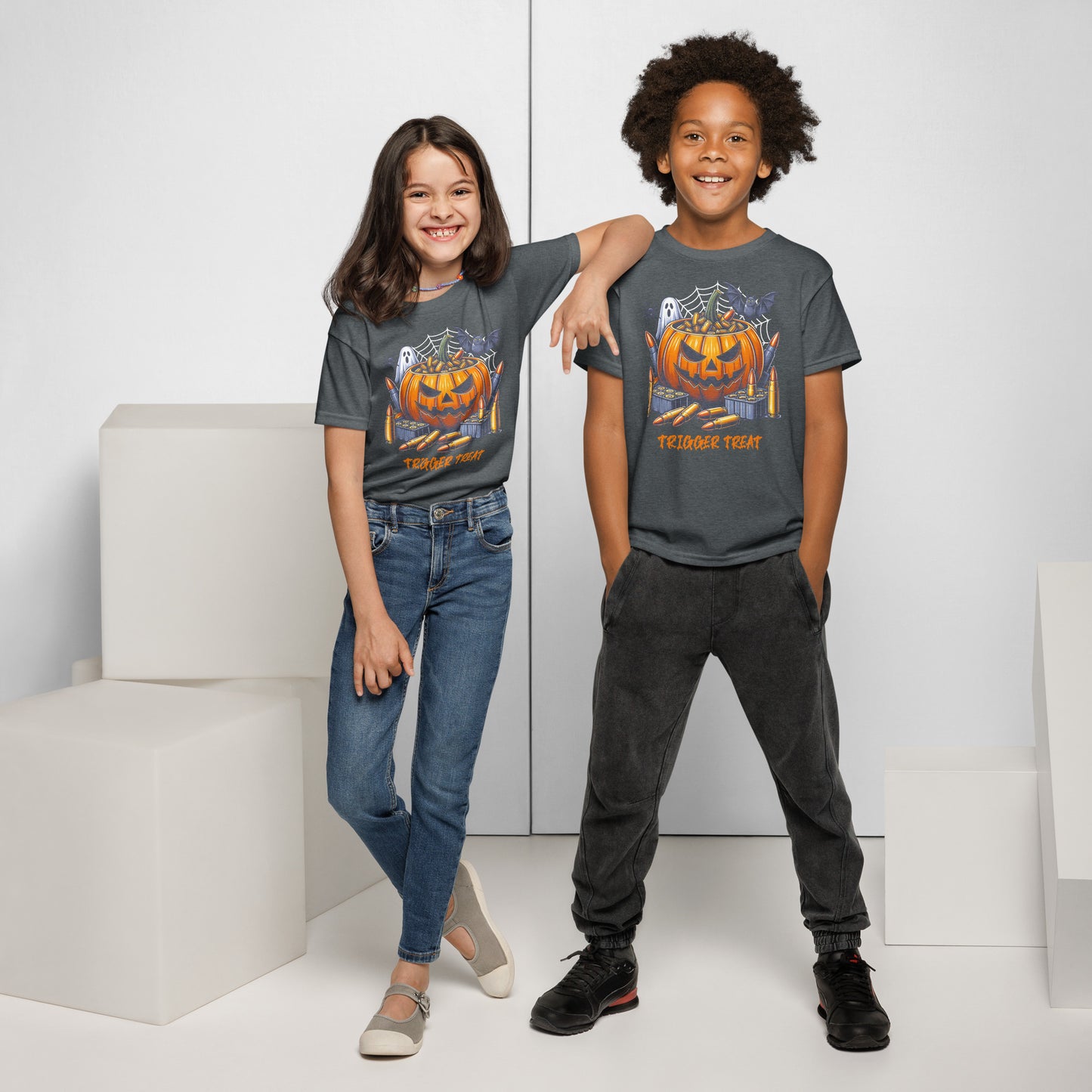 Two children wearing matching Halloween-themed t-shirts in a minimalistic setting.