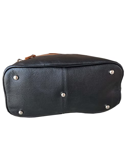 Black pebbled leather bag base showing silver-tone metal studs and a small portion of a brown leather zipper pull on a white background.