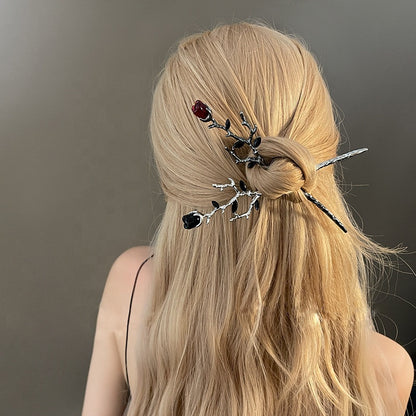 Red and black metal rose hair sticks with thorned branch design shown in women's hair