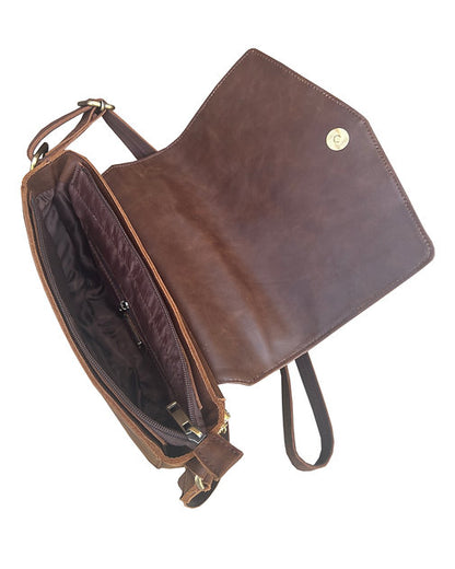 Brown leather bag with a strap on a white background