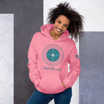 Woman wearing a pink hoodie with a graphic design and text, standing against a gray and white background.