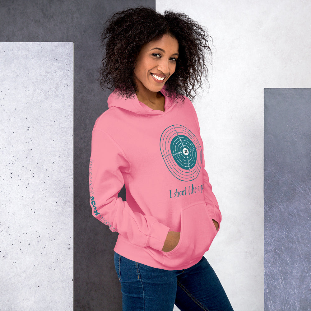 Woman wearing a pink hoodie with a graphic design and text, standing against a gray and white background.