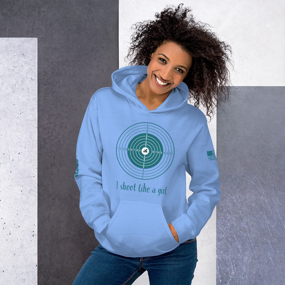 Woman wearing a light blue hoodie with a graphic design and text, standing against a gray and white background.