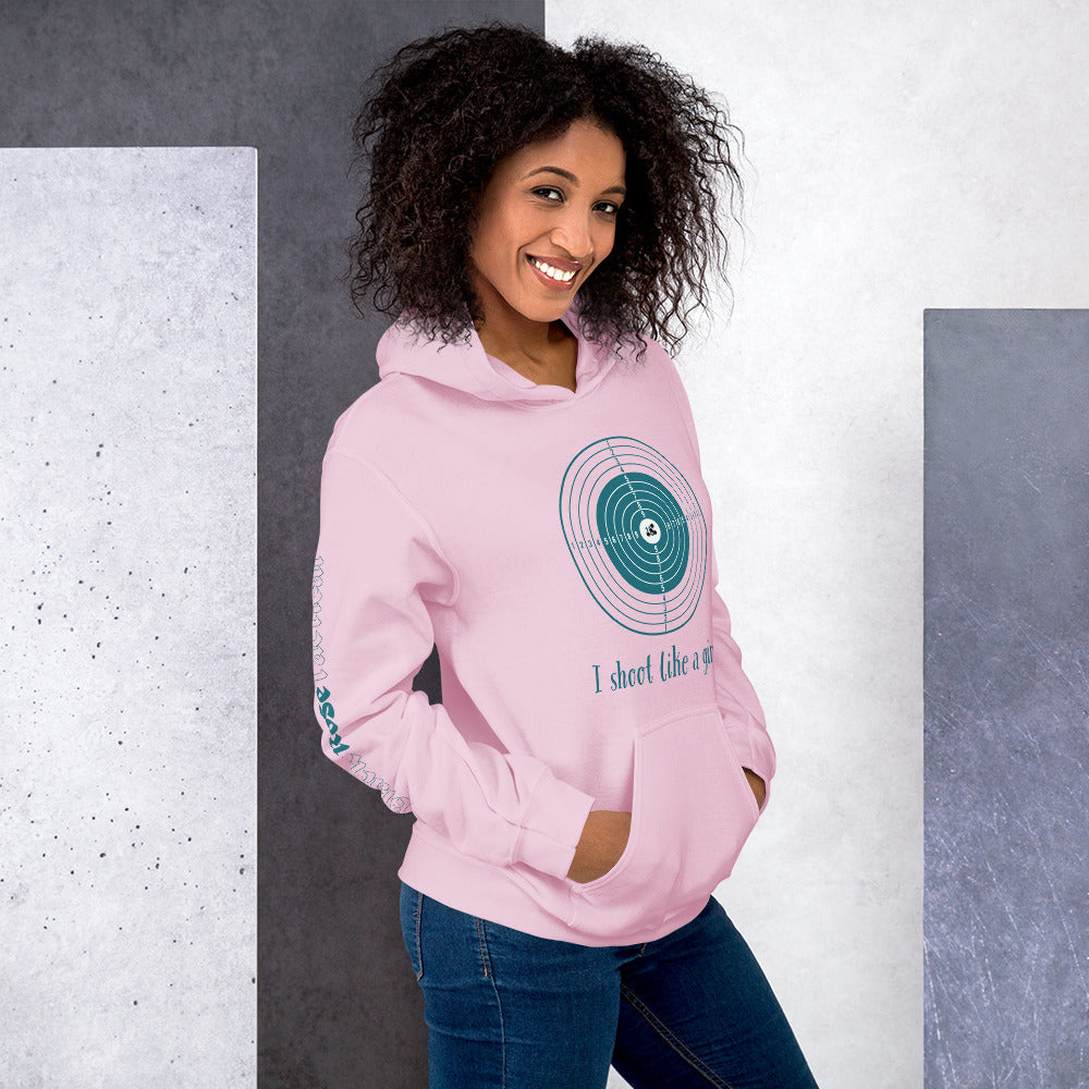 Woman wearing a pink hoodie with a graphic design and text, standing against a gray and white background.