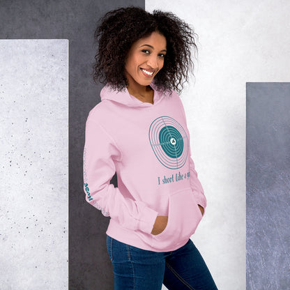 Woman wearing a pink hoodie with a graphic design and text, standing against a gray and white background.
