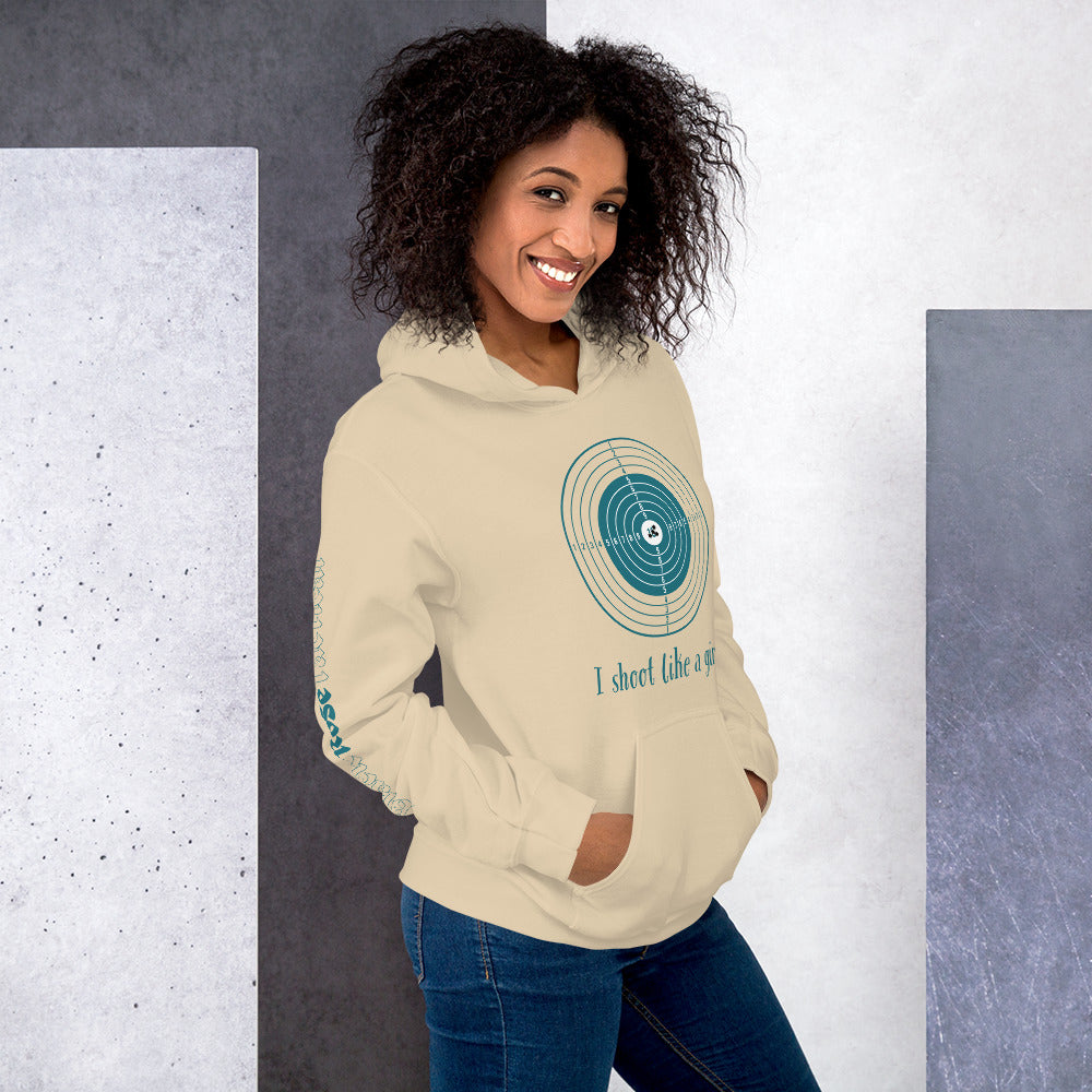 Woman wearing a beige hoodie with a graphic design and text, standing against a gray and white background.