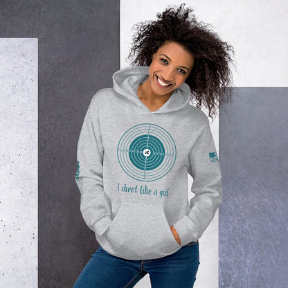 Woman wearing a gray hoodie with a graphic design and text, standing against a gray and white background.