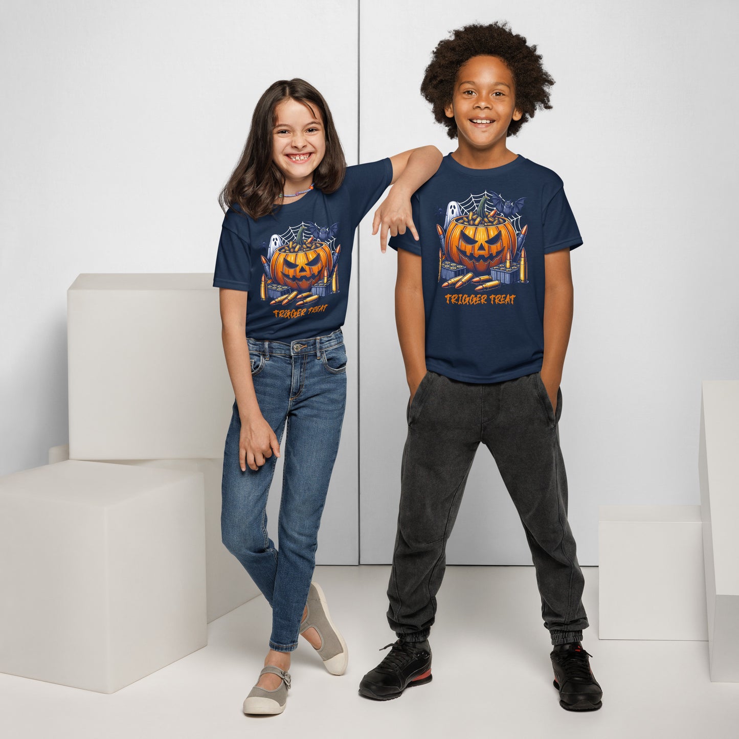 Two children wearing matching blue t-shirts with a pumpkin design on a white background